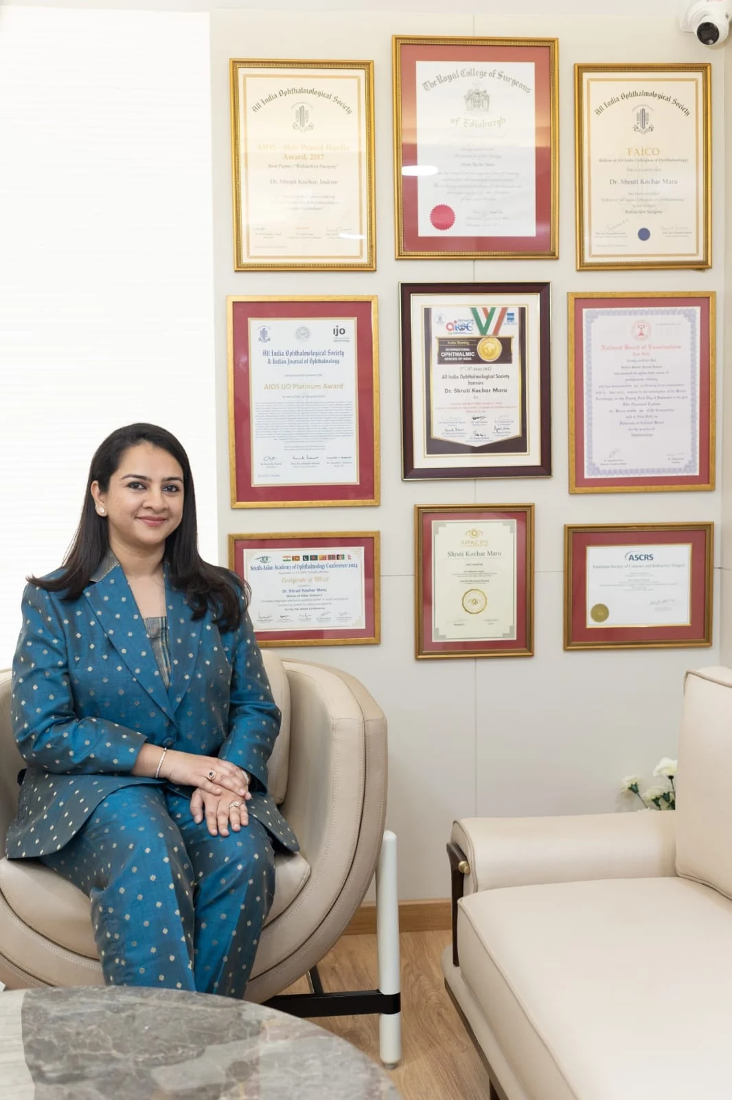 Dr. Shruti Kochar Maru in front of her wall of national and international ophthalmology awards